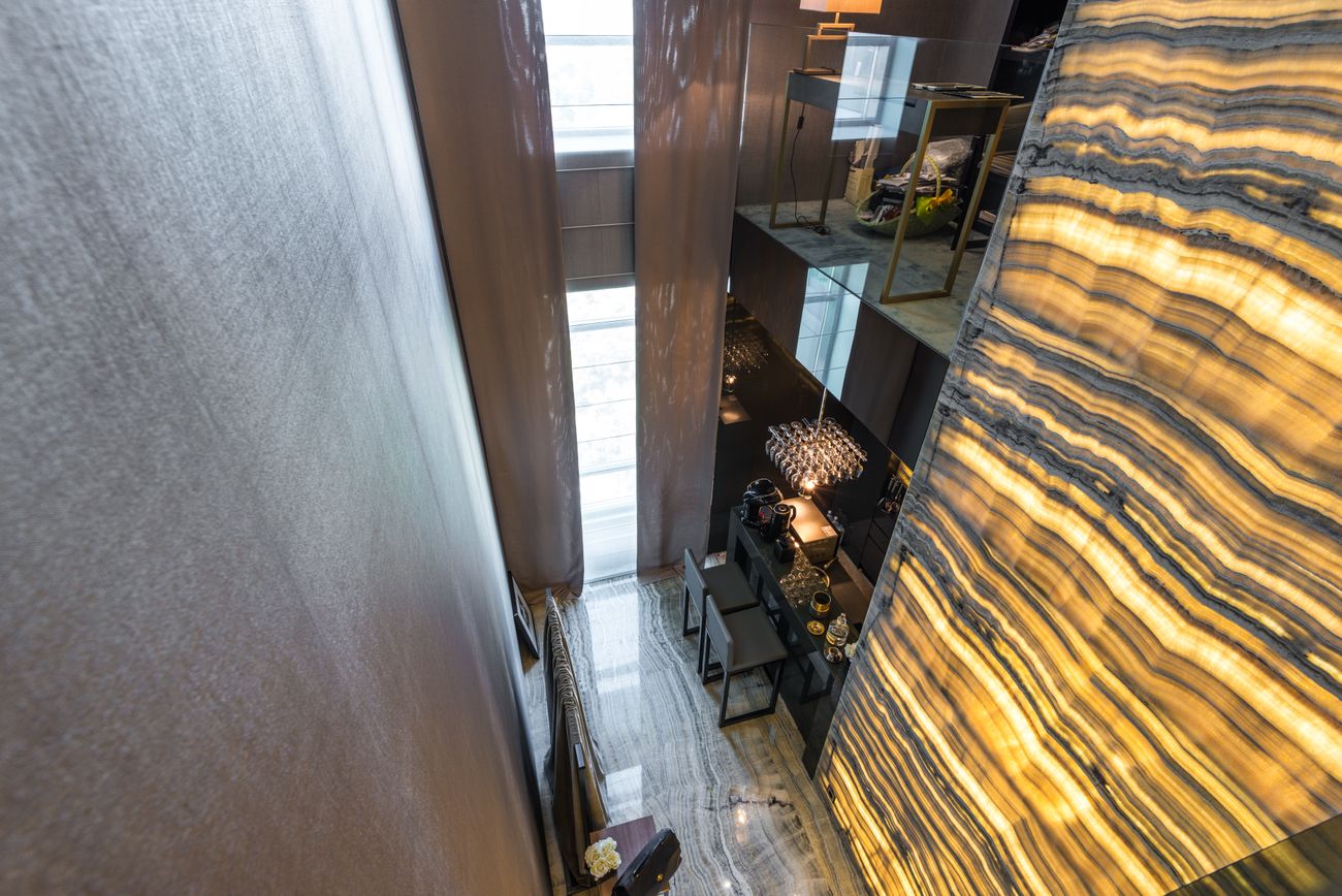 Mur d'onyx rétroéclairé aux veines dorées dans le hall d'honneur