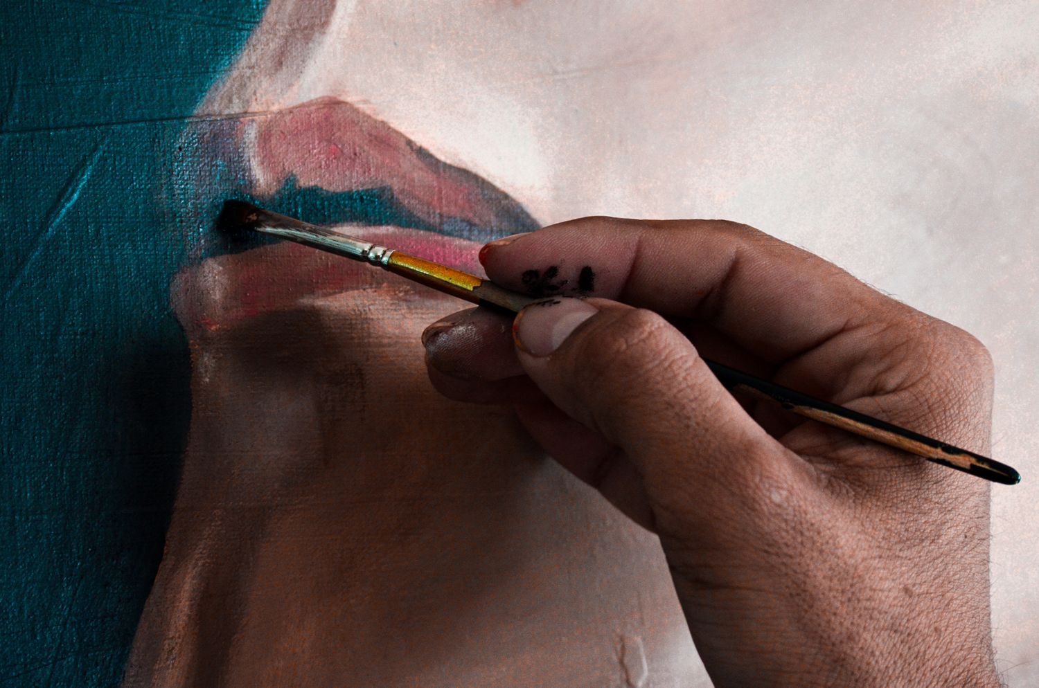 La main de l'artiste posant une touche fine sur un portrait à l'huile