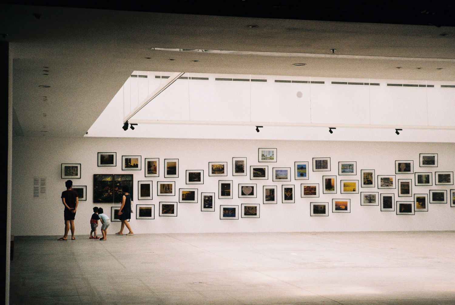 La grande salle de la galerie, petits formats accrochés en constellation sur la cimaise blanche