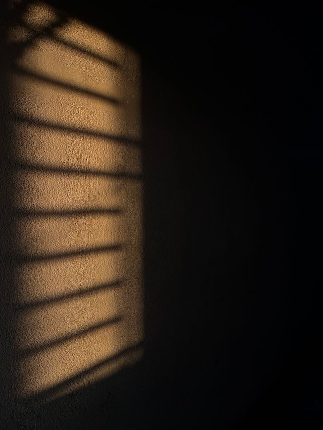 Ombre dure d'une architecture découpée sur un mur au crépuscule