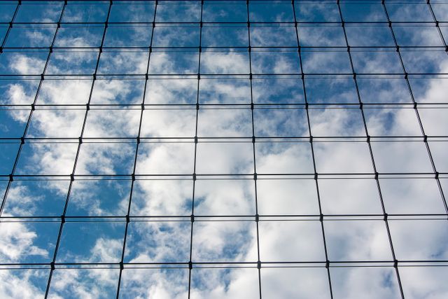 Trame de verre clair où se reflète un ciel de nuages