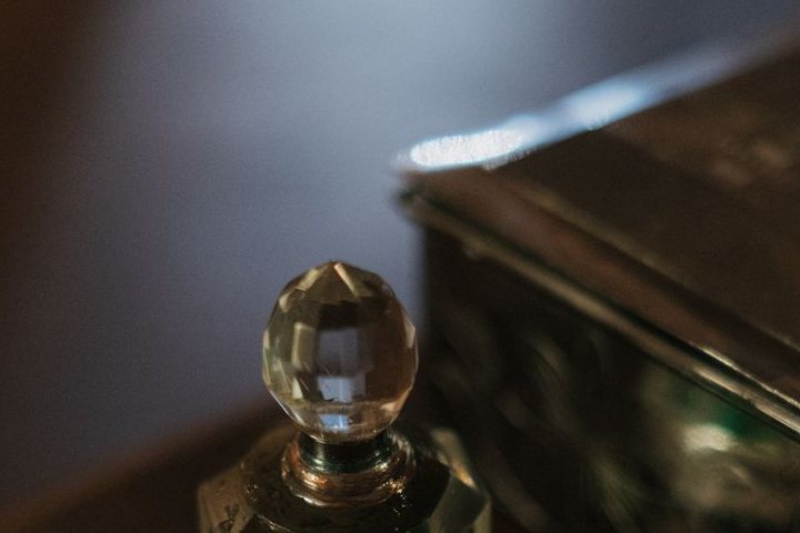 Coiffe de cristal taillé d'un flacon, détail dans la pénombre de l'atelier